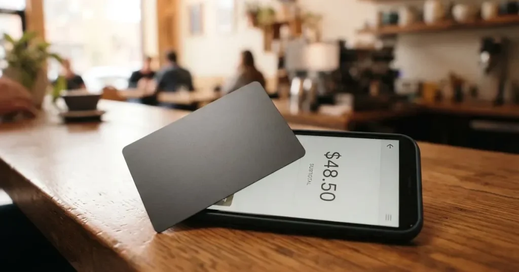 A payment card next to a phone with a crypto wallet app open